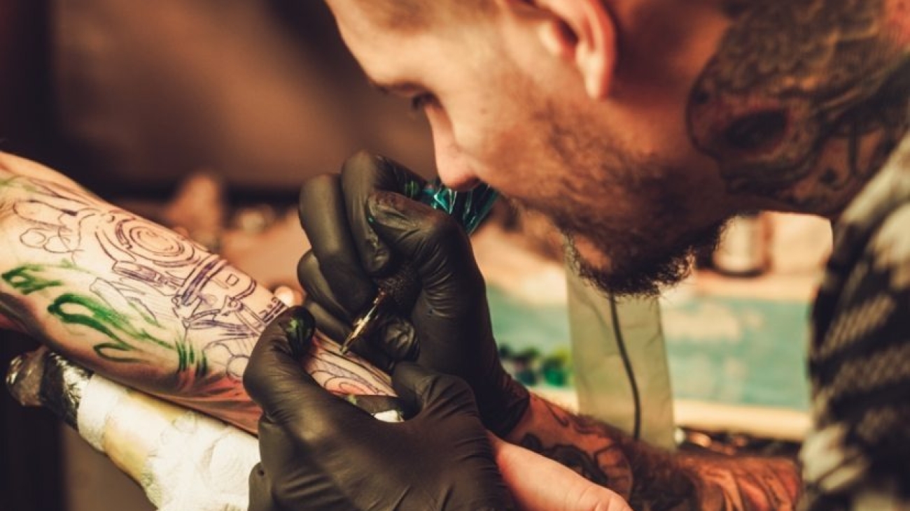 imgi_2_tattoo-artist-makes-a-tattoo-on-a-mans-hand-PECZRE2